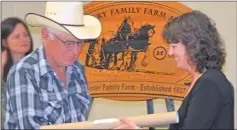  ?? Booster photo by Jason Kerr ?? A member of the Gannon family from Gouldtown accepts a copy of the Gannon's historical land grant at the 2014 ISC Century Family Farm Awards. A total of 71 family farms were recognized in the Swift Current area, out of 308 across the province.