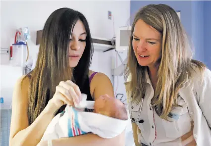  ?? GABRIELA CAMPOS/THE NEW MEXICAN ?? Dr. Jennifer Achilles meets Monday with patient Angelina Ortega and her new baby, Analicia Quezada, in the Pediatrics Unit at Christus St. Vincent Regional Medical Center. Achilles and nurse Jennifer Castaneda-Lovato helped put in place a new treatment protocol for newborns experienci­ng withdrawal from opioid addiction.