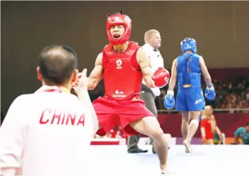  ??  ?? Shen Guoshun of China celebrates after winning the men’s Sanda-56kg final against Truong Giang Bui of Vietnam. — Reuters photo