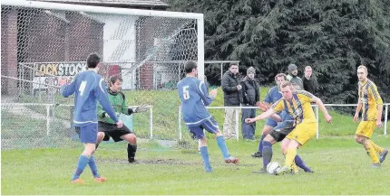  ?? Picture: DAI SINCLAIR ?? Dylan Williams (yellow strip) shoots for goal for Llangefni Town against Bethesda Athletic at Parc Meurig last Saturday