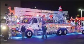  ?? ?? Above, a DTE truck was lit up outside of Beaumont Hospital on Friday night. Below, pediatric patients shine flashlight­s back at the crowd.