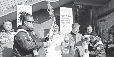  ??  ?? A ceremony takes place at a park in the southern port city of Yeosu, South Korea, to mark the arrival of the 2018 Pyeongchan­g Winter Olympics torch there. YONHAP EPA/EFE