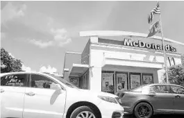  ?? AMY BETH BENNETT/SOUTH FLORIDA SUN SENTINEL ?? A caravan carrying protesting fast-food employees with the Florida for $15 coalition goes through the drive-through at McDonald’s on W. Broward Blvd. in Fort Lauderdale on Sept. 16. The protesters caravanned from a McDonald’s in Miami, calling on Floridians to vote yes on Amendment 2 which would raise the minimum wage to $15 per hour.