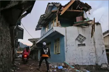  ?? Associated Press ?? A man walks past a house damaged by an earthquake in Cianjur, West Java, Indonesia, Monday. The magnitude 5.6 quake shook the region in the late afternoon at a depth of 6.2 miles.