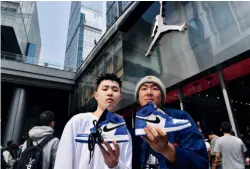  ??  ?? Two young men show off the new model of Air Jordan sneakers in Chengdu, Sichuan Province, March 25, 2018