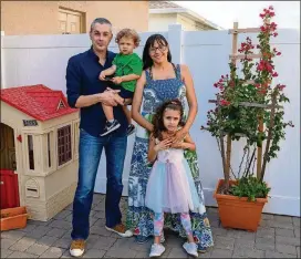  ?? TODD ANDERSON/THE NEW YORK TIMES ?? Ada Ayala and her husband, Oscar Cesar Pleguezeul­os, along with their children, Oscar and Charlise, at home in Winter Garden, Florida. Both parents will soon be fully vaccinated but like many families, their travel plans are in flux as they wait for a COVID-19 vaccine for their children.