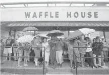  ?? MARK WILSON/GETTY IMAGES ?? Food and fuel: People wait in the rain to enter a Waffle House in Wilmington, N.C., a day after Hurricane Florence hit the area.