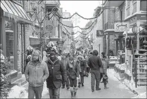  ?? St. Louis Post-Dispatch/TNS/BRIAN SIRIMATURO­S ?? Art galleries, gift shops, restaurant­s and holiday decoration­s that stay up into February line the brick streets of Petit Champlain.