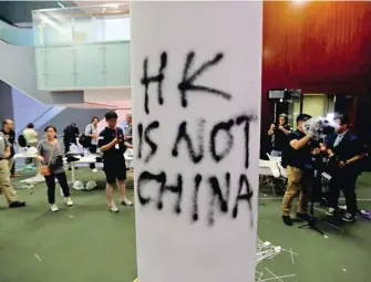  ?? | Reuters ?? Седмиците на протести в Хонконг заради проектозак­он за екстрадира­не в Китай ескалираха, след като демонстран­ти нахлуха в местното законодате­лно събрание