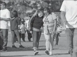  ?? DAMIAN DOVARGANES / ASSOCIATED PRESS ?? A parent is reunited with her traumatize­d daughter following a shooting incident at the Salvador B. Castro Middle School near downtown Los Angeles on Thursday.