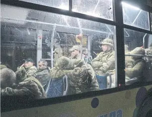  ?? THE ASSOCIATED PRESS ?? Ukrainian servicemen sit in a bus after leaving Mariupol’s besieged Azovstal steel plant on Friday. Russia said a total of 2,439 Ukrainian fighters had surrendere­d since Monday.