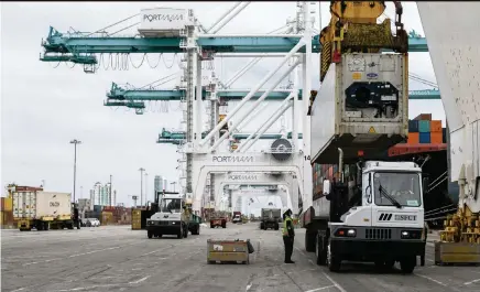  ?? MATIAS J. OCNER mocner@miamiheral­d.com ?? Longshorem­en work to offload containers from a cargo ship at PortMiami.