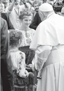  ?? Andrew Medichini / Associated Press ?? Pope Francis greets two girls as he arrives in Iasi, Romania. Francis began a three-day pilgrimage to Romania on Friday.