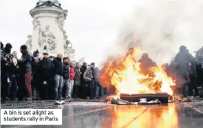  ??  ?? A bin is set alight as students rally in Paris