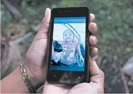  ?? JOHAN ORDONEZ/GETTY-AFP ?? A relative shows a mobile phone picture of 7-year-old Jakelin Amei Rosmery Caal.
