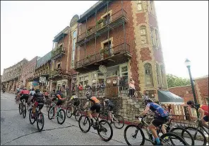  ?? NWA Democrat-Gazette/BEN GOFF ?? Cranking away from Basin Park in downtown Eureka Springs, cross-country racers are able to spread out across the pavement July 16 before reaching the confines of single-track at Lake Leatherwoo­d City Park.
