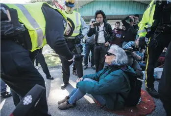  ?? THE CANADIAN PRESS ?? RCMP officers arrest a protester outside Kinder Morgan in Burnaby back on March 17. A judge has set a May 7 trial date for a group of 10 protesters arrested that day.