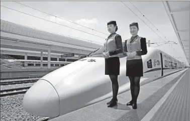  ?? WU WEIHONG / FOR CHINA DAILY ?? Two stewards stand by a CRH (China Railway High-speed) bullet train at Zhanjiangx­i railway station in Zhanjiang, Guangdong province.