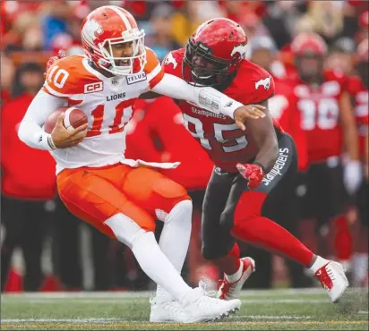  ?? The Canadian Press ?? B.C. Lions quarterbac­k Jonathon Jennings, left, is sacked by Ja’Gared Davis of the Calgary Stampeders during first-half CFL action in Calgary on Saturday night. The Lions lost 27-13.