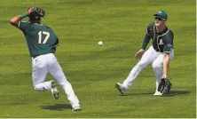  ?? Matt York / Associated Press ?? A’s shortstop Elvis Andrus (17) and left fielder Mark Canha can’t get to a Wilmer Flores bloop in the Giants’ victory.