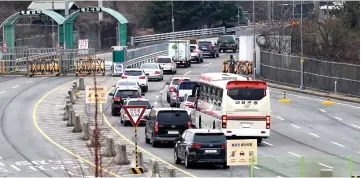  ??  ?? Vehicles carrying South Korean officials of the inter-Korean liaison office head to North Korea’s border city of Kaesong at a border checkpoint, just south of the Demilitari­zed zone dividing the two Koreas, in Paju. — AFP photo