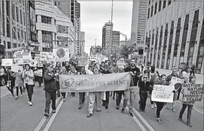  ?? [TOM DODGE/DISPATCH PHOTOS] ?? Thousands gathered Downtown on Saturday for the Columbus March for Science. Dave Buchanan, left, along with Ohio State microbiolo­gist Jenna Antonucci and her husband, Wendell Johnson, carry the lead banner.