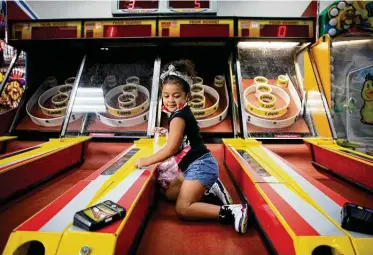  ?? Annie Mulligan / Contributo­r ?? Three-year-old Ahri plays at a Chuck E. Cheese restaurant in Sugar Land. The chain has reopened after closing in March because of the pandemic, with changes including temperatur­e checks and games spaced out for distancing.