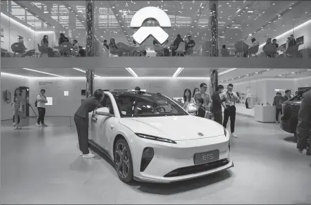  ?? ?? Visitors check out a Nio electric vehicle during an auto expo in Guangzhou, Guangdong province, in November.
