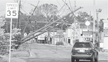  ?? STEVE HELBER/AP ?? Traffic diverts around downed power lines Monday in Metairie, a Jefferson Parish community that is part of the New Orleans metro area. Power outages could have short-term repercussi­ons to energy companies with operations along the Gulf Coast.