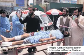  ??  ?? People rush an injured person to hospital in Quetta, Pakistan