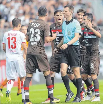  ?? FOTO: IMAGO ?? Diskussion mit Schiedsric­htern gibt es bei fast jedem Fußballspi­el – im Profiberei­ch wie hier mit Benjamin Cortus beim Spiel des FC St. Pauli gegen den 1. FC Köln sowie im Amateurber­eich. Die Folgen in den unteren Ligen sind gravierend.