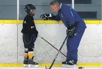  ?? MICHELLE BERG ?? Vancouver Canucks head coach Willie Desjardins gives Daryll Kkailther some tips at Schroh Arena in Saskatoon on Monday. Desjardins is in town for the Driving Fore Prostate Golf Classic fundraiser.