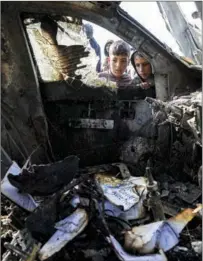  ?? PHOTOS BY AP ?? People inspect destroyed World Central Kitchen vehicles after seven aid workers were killed by Israeli missiles in Deir al-Balah in Gaza on April 2.