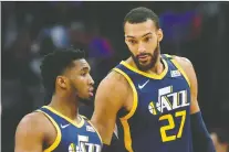  ?? DUANE BURLESON/THE ASSOCIATED PRESS FILES ?? Jazz guard Donovan Mitchell, left, chats with teammate Rudy Gobert during a March 7 game against the Pistons. The NBA suspended its season after Gobert tested positive for the coronaviru­s. Mitchell later tested positive, as well.