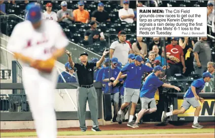  ?? Paul J. Bereswill ?? RAIN MEN: The Citi Field grounds crew races to get out the tarp as umpire Kerwin Danley signals a rain delay during the first inning of the Mets’ 6-1 loss to the Reds on Tuesday.