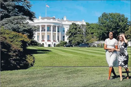  ?? JUANJO MARTIN / AFP ?? La reina Letizia, del brazo de Michelle Obama, camina por los jardines de la Casa Blanca