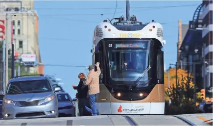  ?? MIKE DE SISTI / MILWAUKEE JOURNAL SENTINEL ?? Pedestrian­s wave as The Hop heads south on North Broadway near East Wisconsin Avenue on a test drive Thursday. While much of the testing to date has been done in the evening and overnight hours, daytime testing began on Monday. More photos and video at jsonline.com.