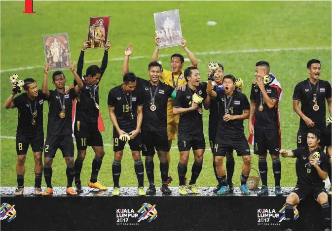  ??  ?? KUALA LUMPUR: Thailand’s football team players celebrate on the podium after defeating Malaysia during their men’s football final match of the 29th Southeast Asian Games (SEA Games) at Shah Alam Stadium, outside Kuala Lumpur yesterday.