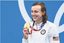  ?? Jonathan Nackstrand / AFP via Getty Images ?? Katie Ledecky shows off her medal from the women’s 800meter freestyle, her third gold from that race.