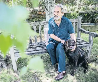  ??  ?? El músico en el jardín de su casa, con uno de sus dos perros