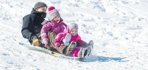  ?? BRANDON HARDER ?? Dan Drackett and daughters Stella, 4, and Hazel, 2, slide down a hill at Pascoe Park in the Crescents neighbourh­ood on Wednesday.