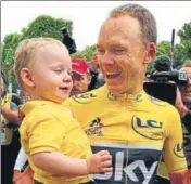  ??  ?? Tour de France winner Chris Froome holds his son Kellan after the last stage in Paris on Sunday.