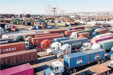  ?? NOAH BERGER/AP 2021 ?? Trucks line up to enter a shipping terminal Nov. 10 in Oakland, Calif. Currently, truckers who cross state lines must be 21.