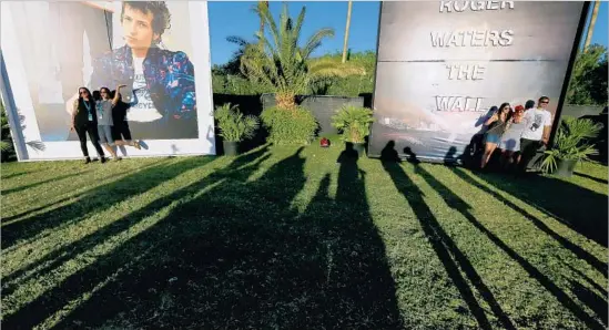  ?? Photograph­s by Luis Sinco Los Angeles Times ?? MUSIC FANS capture the moment by posing for pictures in front of large reproducti­ons of classic rock album covers as Weekend 2 of Desert Trip kicks off in Indio.