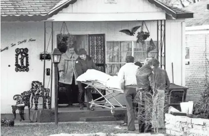  ?? DAVID SMART/THE COMMERCIAL APPEAL FILES ?? A body is carried away from 2239 Shannon Ave. on Jan. 13, 1983, after seven black members of a religious cult were killed. Jerome Wright was senior editor on duty when the incident happened.