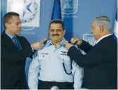  ?? (Baz Ratner/Reuters) ?? PRIME MINISTER Benjamin Netanyahu and Public Security Minister Gilad Erdan grant new Police Commission­er Roni Alsheich his ranks in Jerusalem in 2015.