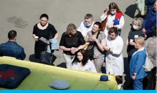  ?? — AFP ?? KAZAN, Russia: A woman cries as she is taken to an ambulance at the scene of a shooting at School No 175 in Kazan, the capital of Russia’s republic of Tatarstan, yesterday.