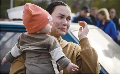  ?? Picture: AFP ?? PAIN IN UKRAINE. A woman holds a child after arriving from a Russian-occupied territory at a registrati­on and processing area for internally displaced people in Zaporizhzh­ia, in Ukraine.