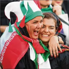  ?? AMIN M. JAMALI / GETTY IMAGES ?? Iranian women celebrate Thursday during a World Cup qualifier between Iran and Cambodia in Tehran, Iran.