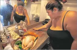  ??  ?? VANESSA PADILLA, 30, tries to clean a turkey in the small room at the Country Inn that she shares with her four children.